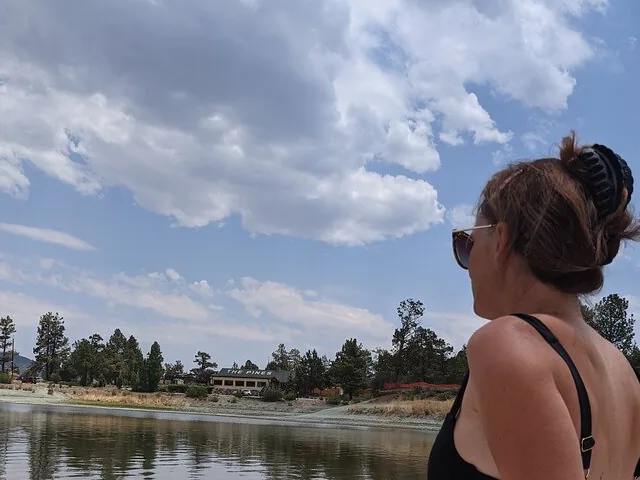 Woman looking at Big Bear Lake and a building on the shore